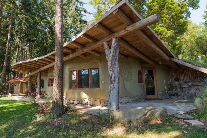 a wooden cobhouse home in green vegetation