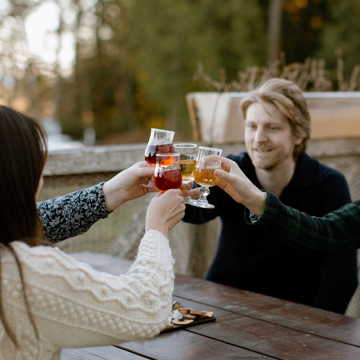 People cheersing on the Sea Cider patio