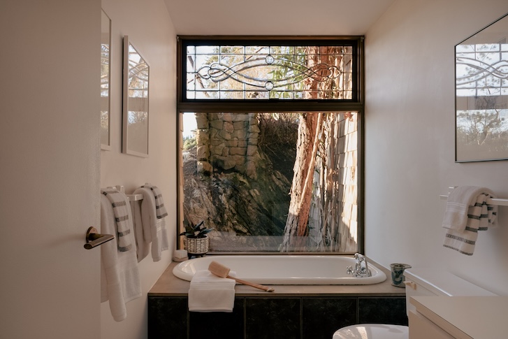 ensuite bathroom with bathtub and a see-through window