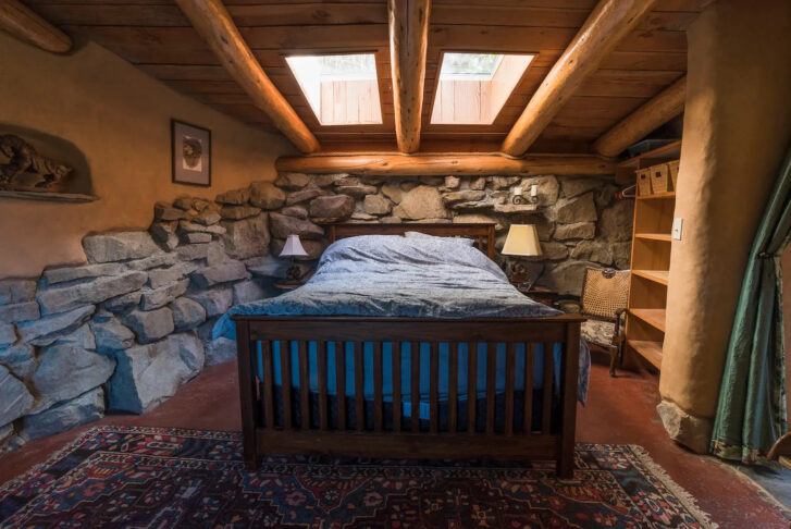 a bedroom in a home featuring a queen-sized bed with a skylight above