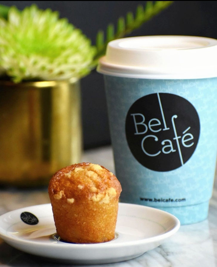 a coffee cup with the words 'Bel Café' and a brown muffin on sauce plate