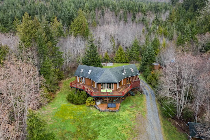 aerial view of island coastal home with green trees and vegetation around