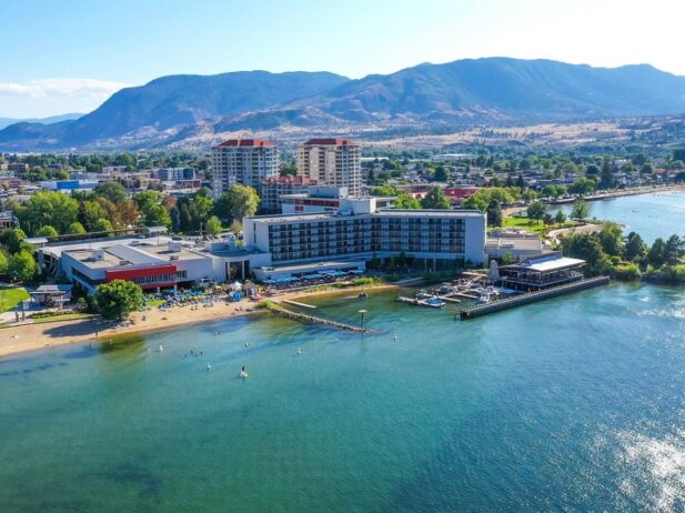 aerial view of a massive resort buildings behind a huge lake with a beach area