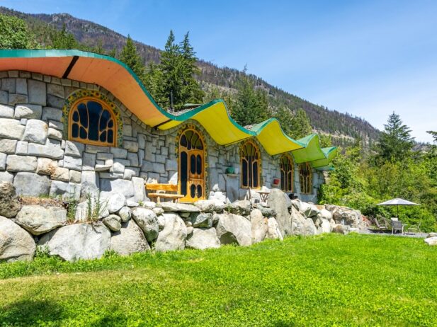 an ‘Earthship’ dream home, an undulating roof with a vibrant green and orange glaze with the inner and outer wall of the property made of exposed stone