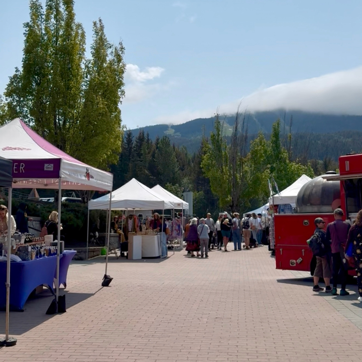 the outdoor Whistler farmers market with the mountains in the background