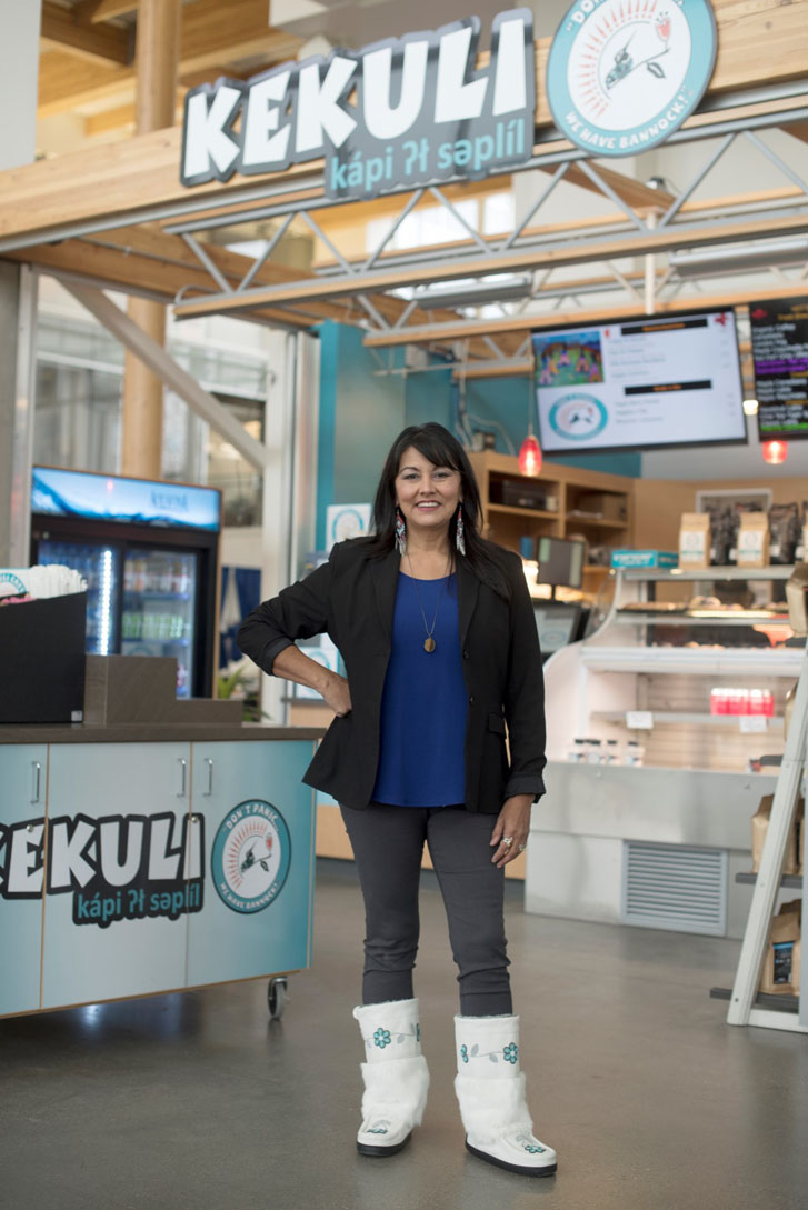 a woman standing in front of a checkout corner that has the words "Kekuli Café" on its front in a restaurant