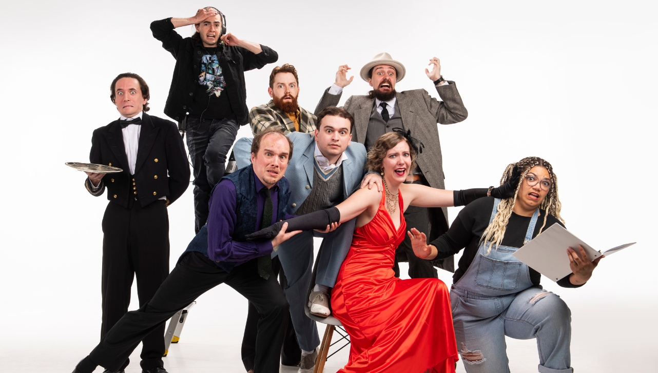 a group of dressed theatre performers making faces and stances