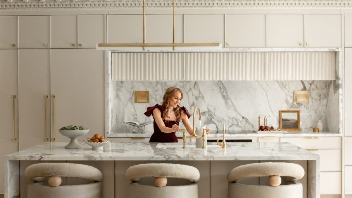 woman in a kitchen filling a water jug with water from a running tap on the kitchen island