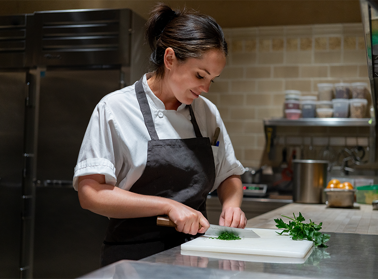 Chef Heather cutting herbs in the Mission Hill kitchen