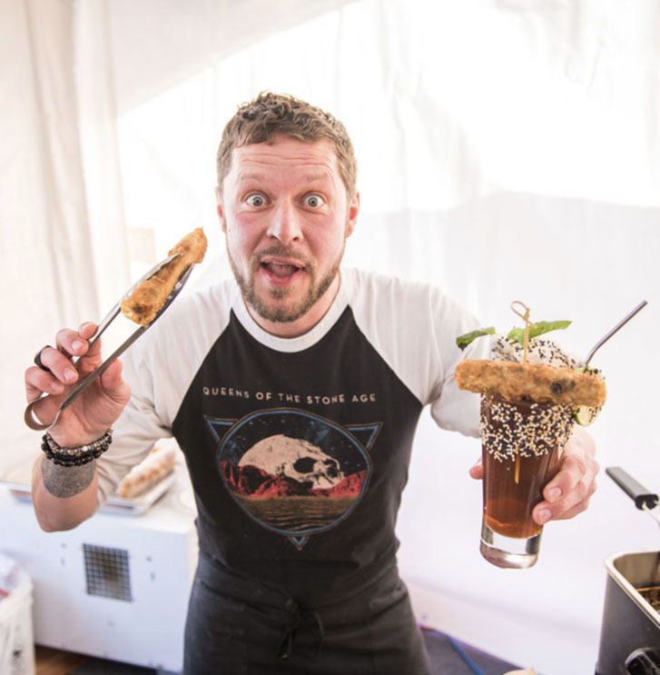 a man holding a fried clam on his right and a beer with another clam on the other