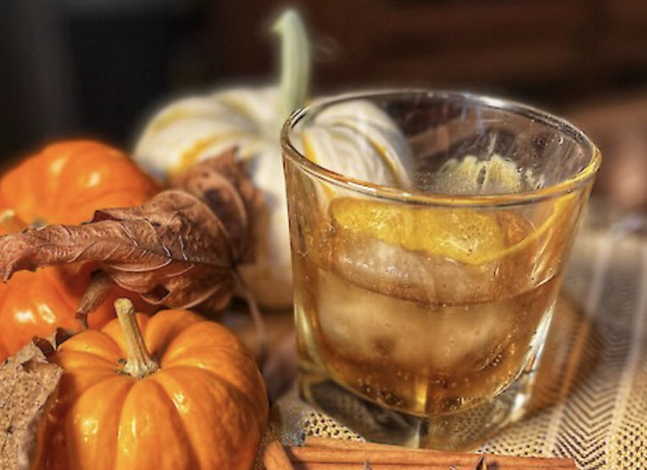 small pumpkins beside a drink in a glass