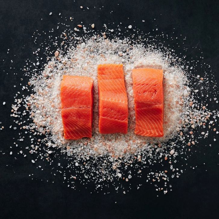 three cuts of Wild BC Salmon on a pile of salt