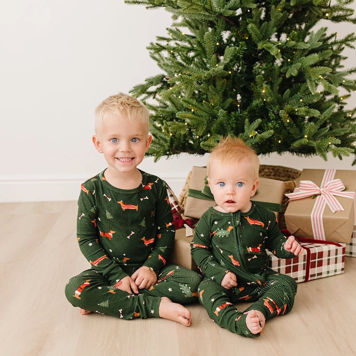 two kids wearing Sunday Littles' Slumber Pajama set in front of a Christmas tree