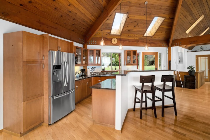 kitchen area with an island, fridge, and wooden stools