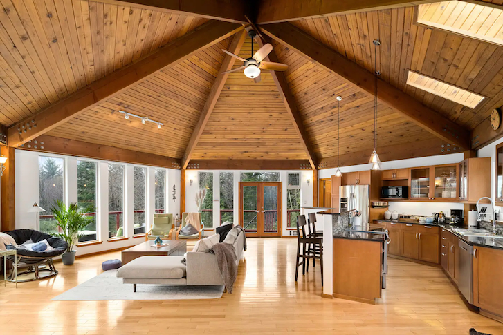 cedar beams along a high vaulted ceiling and wooden stools in room interior