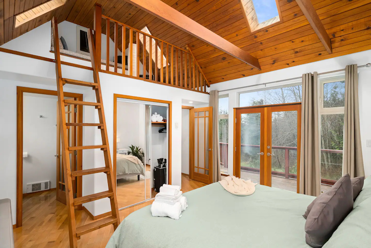 wooden ladder leading up to a smaller resting room from master bedroom