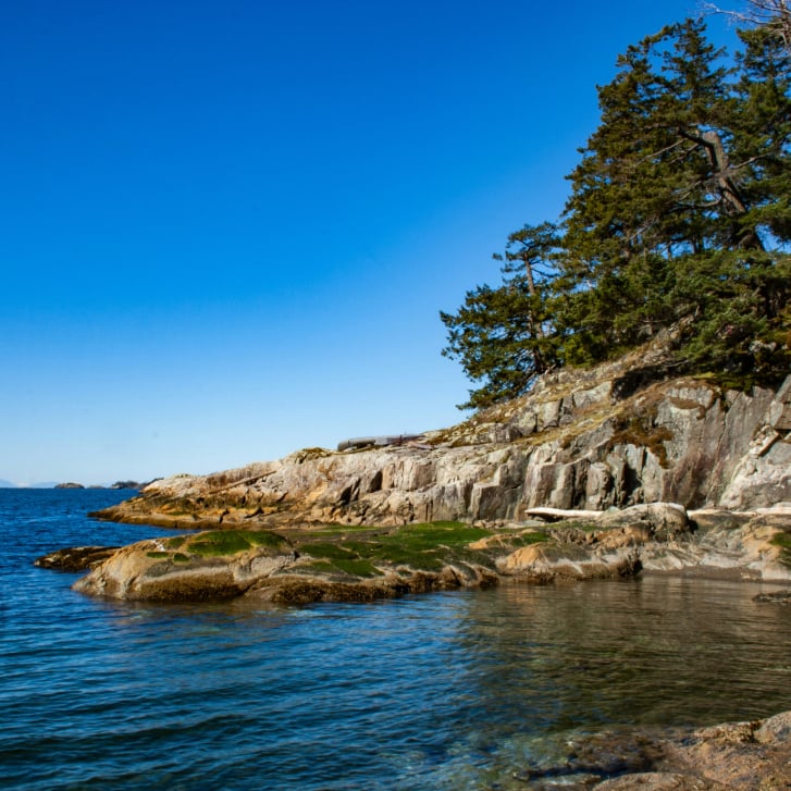 brown-rocky-mountain-beside-blue-sea-under-blue-sky-during-daytime