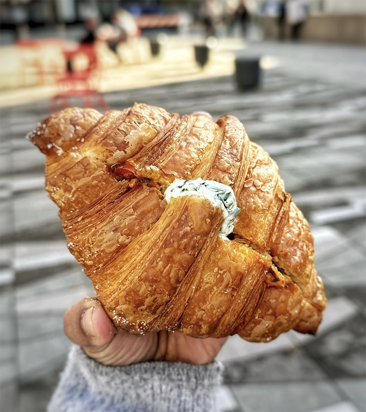 A hand holding a croissant