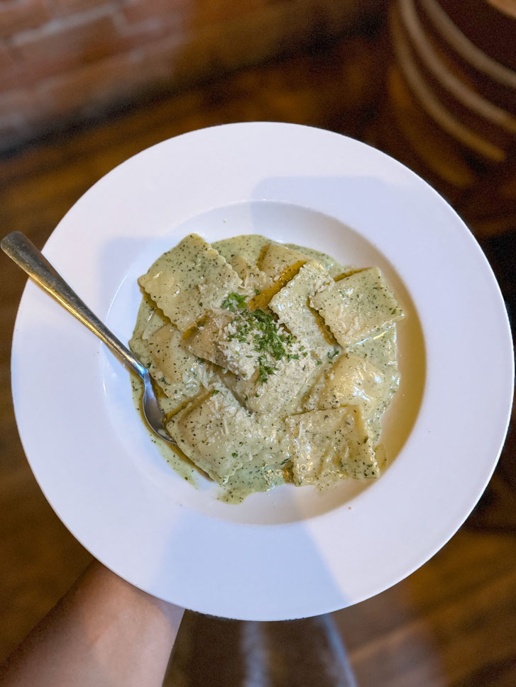 a pasta meal in a white plate with a spoon