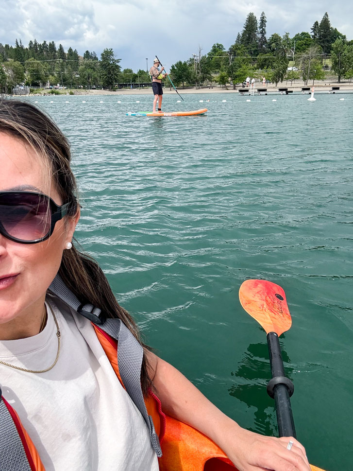 a woman and man paddling on different paddle boards on the lake