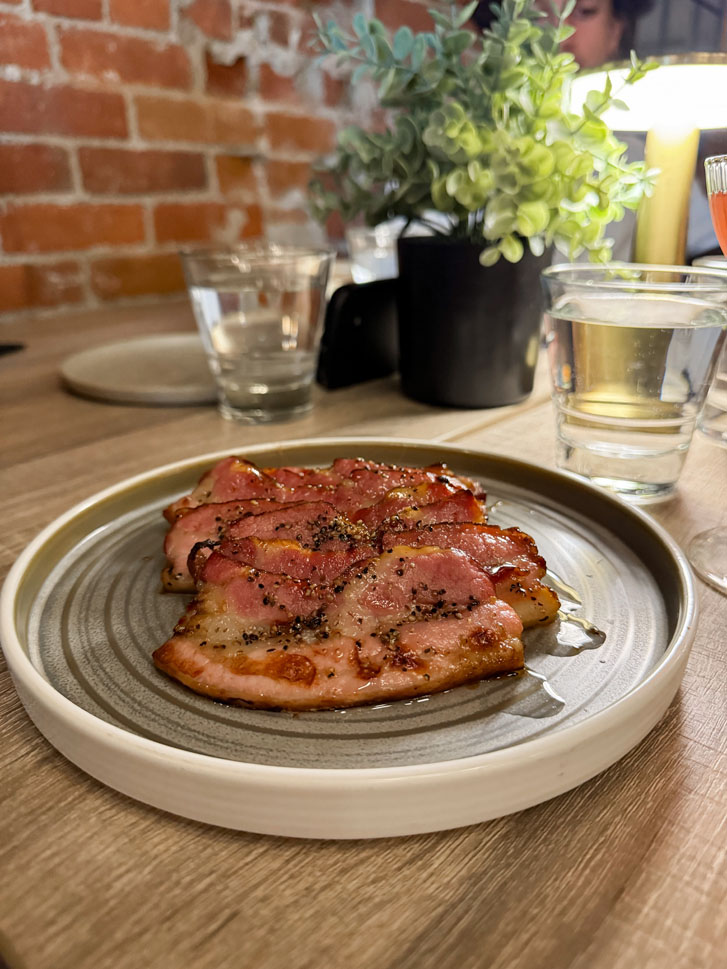 Cooked Steak slices on a plate with glasses of water beside it