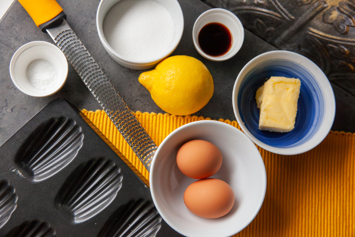 eggs, lemon, butter, and baking pan as ingredients for madeleine recipe
