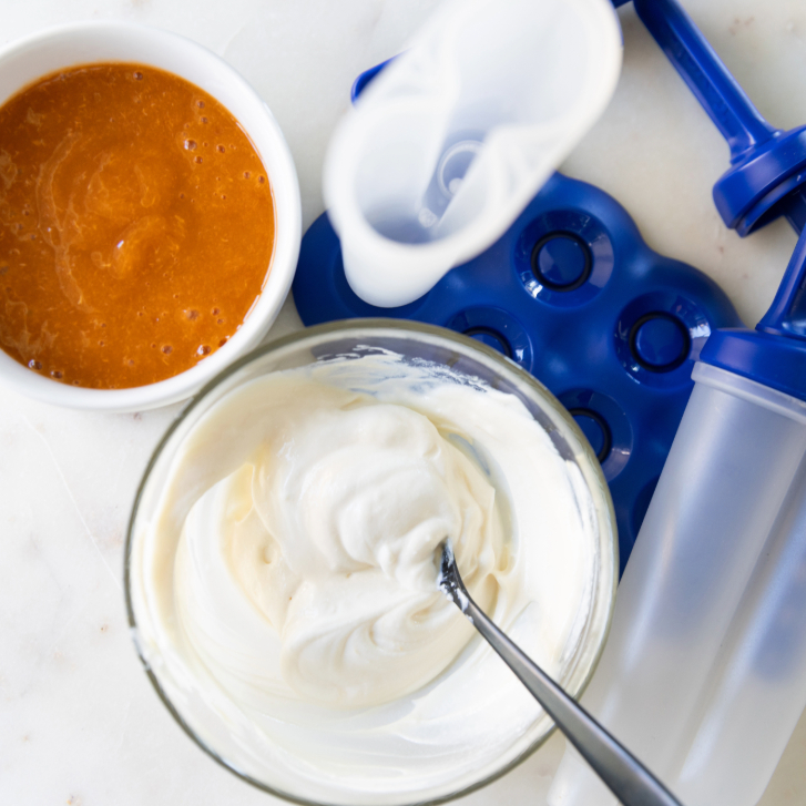 yogurt and blended fruit next to a mould for a fruit popsicle recipe