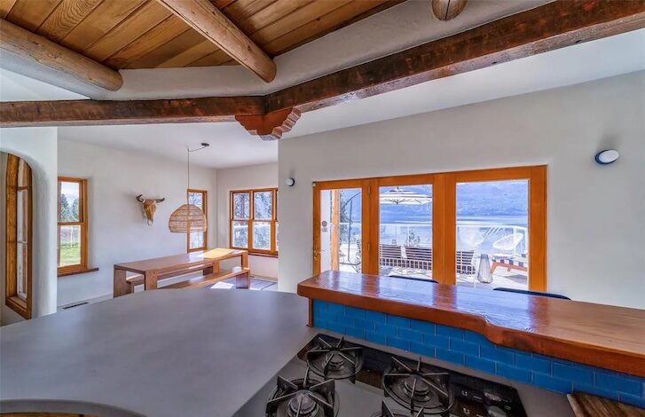 a large open room space with windows overlooking outside to the lake