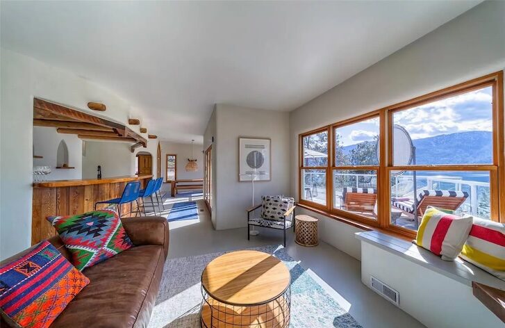 a sitting room with large window, a couch and a centrepiece table