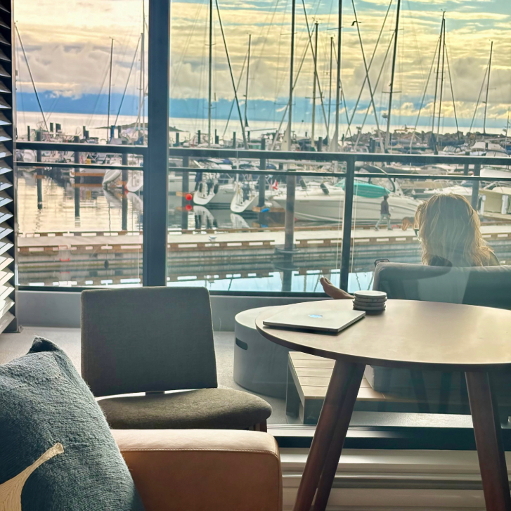 person sitting on a balcony at the Fairwinds Residences overlooking the marina at sunset in Nanoose Bay